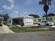 Inviting single-story home with lush green lawn, mature landscaping, and a quaint front facade at 845 S Green Cir, Venice, FL 34285