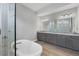 Spacious bathroom with double vanity, grey cabinets, granite countertop, soaking tub and tiled shower at 8962 Baroque Ter, Sarasota, FL 34240