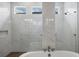 Elegant bathroom features a modern tub with marble tile surround, glass shower and clerestory windows at 8962 Baroque Ter, Sarasota, FL 34240