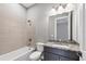 Bathroom featuring tiled shower-tub and granite vanity with dark wood cabinets at 8962 Baroque Ter, Sarasota, FL 34240
