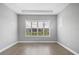 Bright empty room with wood floors, neutral paint, and plantation shutters at 8962 Baroque Ter, Sarasota, FL 34240