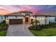 Elegant home featuring a well-manicured lawn, paver driveway, and a three-car garage at 8962 Baroque Ter, Sarasota, FL 34240