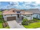Elegant home featuring a well-manicured lawn, paver driveway, and a three-car garage at 8962 Baroque Ter, Sarasota, FL 34240
