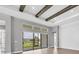 Living room featuring high ceilings with exposed wood beams and large glass doors with view of backyard at 8962 Baroque Ter, Sarasota, FL 34240