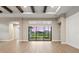 Spacious living room with wood-look flooring and sliding glass doors with a lake view at 8962 Baroque Ter, Sarasota, FL 34240