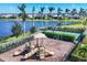 Community playground with slides, swings, and a basketball court is located near a lake, surrounded by palm trees at 8962 Baroque Ter, Sarasota, FL 34240