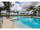 Large community pool featuring plenty of seating, palm trees and clear blue water at 8962 Baroque Ter, Sarasota, FL 34240