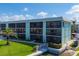 Beautiful building featuring expansive windows, lush green lawns, and direct water access at 9200 Midnight Pass Rd # 30, Sarasota, FL 34242