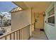 Exterior hallway with textured stucco, safety features, and view of homes and street at 9200 Midnight Pass Rd # 30, Sarasota, FL 34242