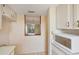 Cozy kitchen pass-through with white cabinets providing an open view of the living area at 9200 Midnight Pass Rd # 30, Sarasota, FL 34242