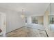 Bright living room with marble floors, chandelier, and sliding door access to the balcony at 9200 Midnight Pass Rd # 30, Sarasota, FL 34242