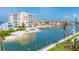 Picturesque waterfront featuring a sandy beach, palm trees, and views of a building complex at 9200 Midnight Pass Rd # 30, Sarasota, FL 34242