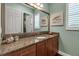 Bathroom with wooden cabinets, granite countertop and a large mirror at 932 Mangrove Edge Ct, Bradenton, FL 34208