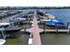 Close up view of boat slips at a marina, showing various boats and boat lifts on the water at 932 Mangrove Edge Ct, Bradenton, FL 34208