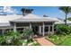 Stunning clubhouse entrance with a red brick walkway, manicured landscaping, and a welcoming architectural design at 932 Mangrove Edge Ct, Bradenton, FL 34208