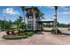 A secure gated entrance, featuring attractive architecture, ensures privacy within the lush, tropical community at 932 Mangrove Edge Ct, Bradenton, FL 34208