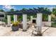 Outdoor kitchen with built in barbeque, pergola covered seating area, and lush tropical landscaping at 932 Mangrove Edge Ct, Bradenton, FL 34208