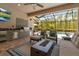 Covered outdoor kitchen with a grill, bar, and a view of the pool area at 932 Mangrove Edge Ct, Bradenton, FL 34208