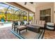 Screened-in patio with comfortable seating around a fire pit and a view of the pool at 932 Mangrove Edge Ct, Bradenton, FL 34208