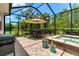 Screened-in patio showcases an outdoor kitchen, grill, dining area, and spa overlooking the backyard at 932 Mangrove Edge Ct, Bradenton, FL 34208