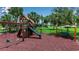 Community playground with play structure, swings, and seating surrounded by lush landscaping at 932 Mangrove Edge Ct, Bradenton, FL 34208