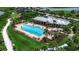 Aerial view of the community pool area, featuring a large pool, sun loungers, seating and a playground at 932 Mangrove Edge Ct, Bradenton, FL 34208