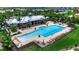 Community pool with lounge chairs, seating area, manicured lawn and tropical landscaping in the background at 932 Mangrove Edge Ct, Bradenton, FL 34208