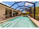 Inviting screened-in pool featuring a spa, outdoor kitchen, and ample space for entertaining guests at 932 Mangrove Edge Ct, Bradenton, FL 34208