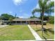 Charming single-story brick home featuring a covered front porch and lush green lawn on a sunny day at 2720 12Th Ave W, Bradenton, FL 34205