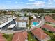 Aerial view of condo community with pool, assigned parking, and ocean in the distance at 110 Vista Hermosa Cir # 302B, Sarasota, FL 34242
