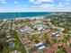 Overhead view of a community with a red-tile roofed home, a pool, and proximity to the beach at 110 Vista Hermosa Cir # 302B, Sarasota, FL 34242