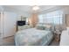 Bright bedroom featuring a queen bed, dresser with TV, and a ceiling fan at 110 Vista Hermosa Cir # 302B, Sarasota, FL 34242