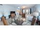 Open-concept dining area with glass table, wicker chairs, and view of the living space at 110 Vista Hermosa Cir # 302B, Sarasota, FL 34242