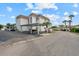 Exterior view of a two-story condo building with assigned parking and manicured landscaping at 110 Vista Hermosa Cir # 302B, Sarasota, FL 34242