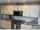 Kitchen with stainless appliances, granite counters, white cabinets, and subway tile backsplash at 110 Vista Hermosa Cir # 302B, Sarasota, FL 34242