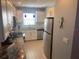 Open kitchen with stainless appliances, granite counters, white cabinets, and blue pendant lighting at 110 Vista Hermosa Cir # 302B, Sarasota, FL 34242