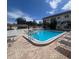 Community pool with surrounding brick patio, lounge chairs and trees beyond at 110 Vista Hermosa Cir # 302B, Sarasota, FL 34242