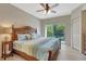 Spacious bedroom featuring light wood floors, ceiling fan, balcony access, and a large decorative wood headboard at 1216 Rio De Janeiro Ave # 306, Punta Gorda, FL 33983