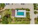 Aerial view of the community pool featuring a rectangular pool, lounge chairs, umbrella tables, and parking at 1216 Rio De Janeiro Ave # 306, Punta Gorda, FL 33983
