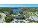 Expansive aerial view showcasing the community's clubhouse, pool, lake, and surrounding landscape at 12229 Stuart Dr, Venice, FL 34293