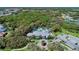 Aerial view of the Grand Palm community clubhouse, pool, parking and surrounding wooded landscape at 12229 Stuart Dr, Venice, FL 34293