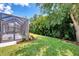 Lush backyard showcasing a well-maintained lawn and a screened patio, creating a private outdoor oasis at 12229 Stuart Dr, Venice, FL 34293