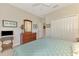Bedroom with a closet, wooden dresser, tv and patterned blue bedding at 12229 Stuart Dr, Venice, FL 34293