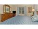 Bedroom with large wooden dresser, mirror and comfortable blue patterned bedding at 12229 Stuart Dr, Venice, FL 34293