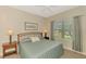 Bedroom with a window, bedside tables with lamps, and carpeted floors at 12229 Stuart Dr, Venice, FL 34293