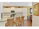 Stylish kitchen featuring white cabinetry, granite counters, a breakfast bar, and stainless steel appliances at 12229 Stuart Dr, Venice, FL 34293