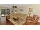 Cozy living room featuring comfortable seating, a ceiling fan, and sliding doors to a screened-in lanai at 12229 Stuart Dr, Venice, FL 34293