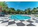 Beautiful pool area surrounded by palm trees and black and white tiling at 12229 Stuart Dr, Venice, FL 34293