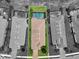 Aerial view showing the rectangular pool of a home surrounded by lush green grass and neighboring houses at 12856 Sorrento Way, Bradenton, FL 34211