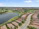 Stunning aerial view of homes with lush landscaping, overlooking a serene lake and green golf course at 12856 Sorrento Way, Bradenton, FL 34211